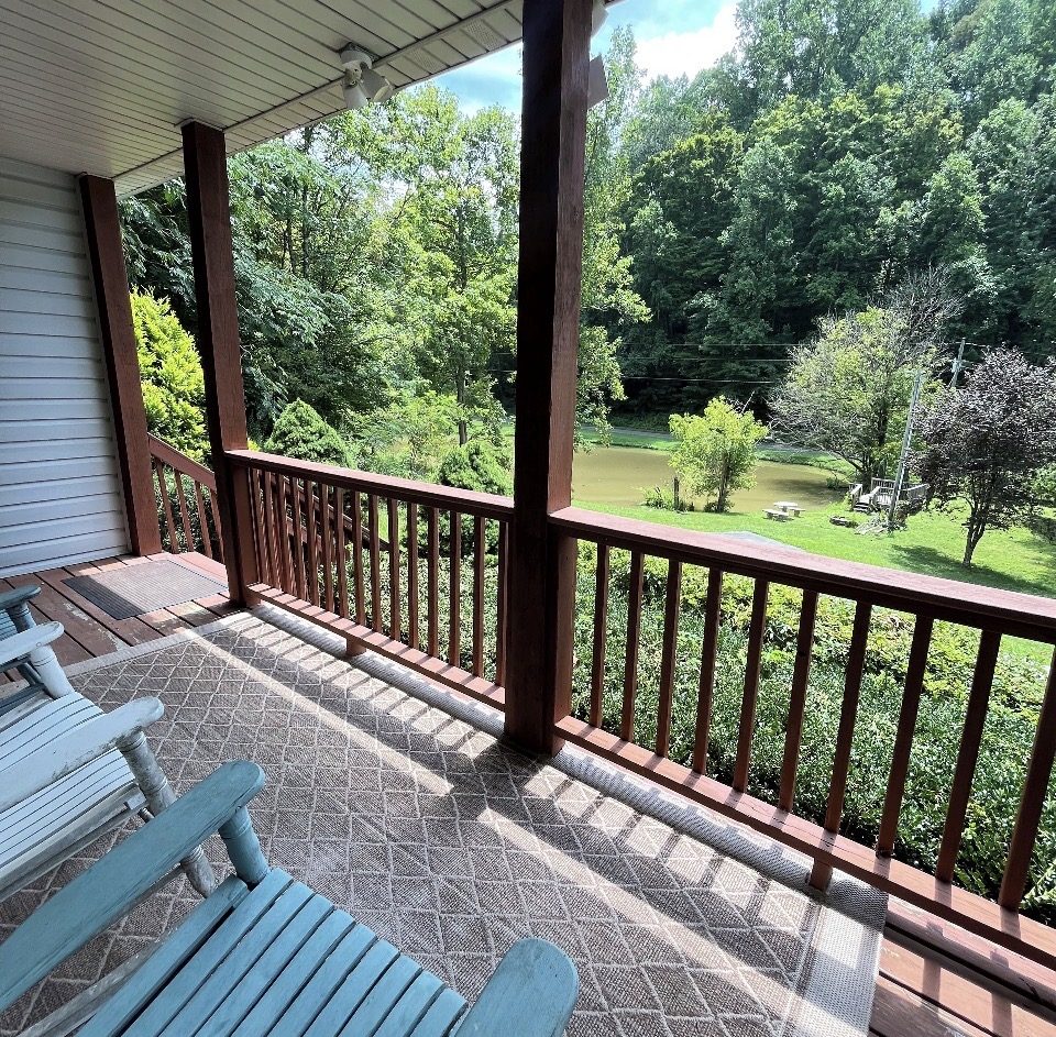 Rocking chairs on the covered porch overlooking the private pond