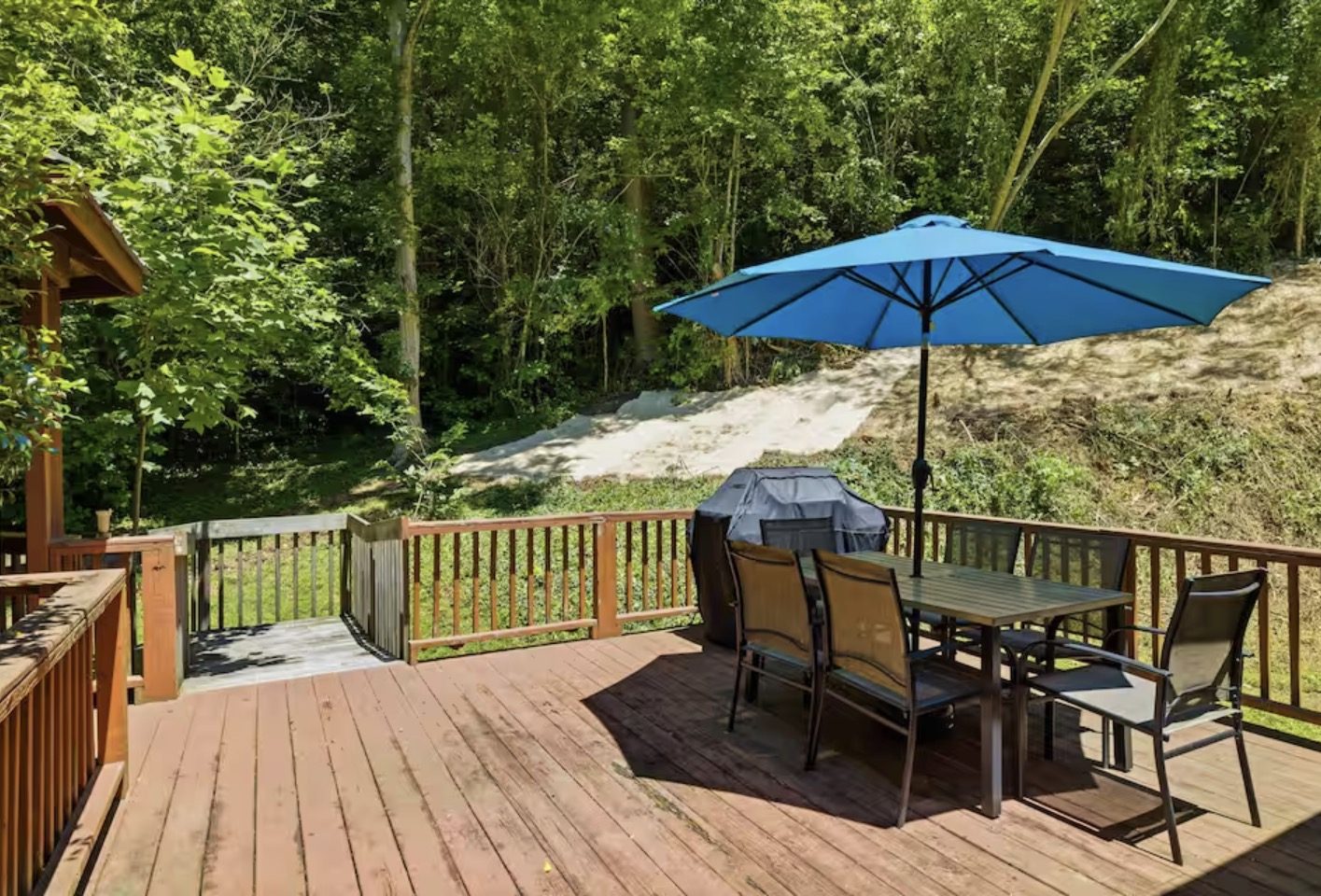 Back deck with grill and umbrella dining table over the woods